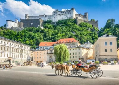 Blick über Salzburg mit Schloss und Pferdekutsche